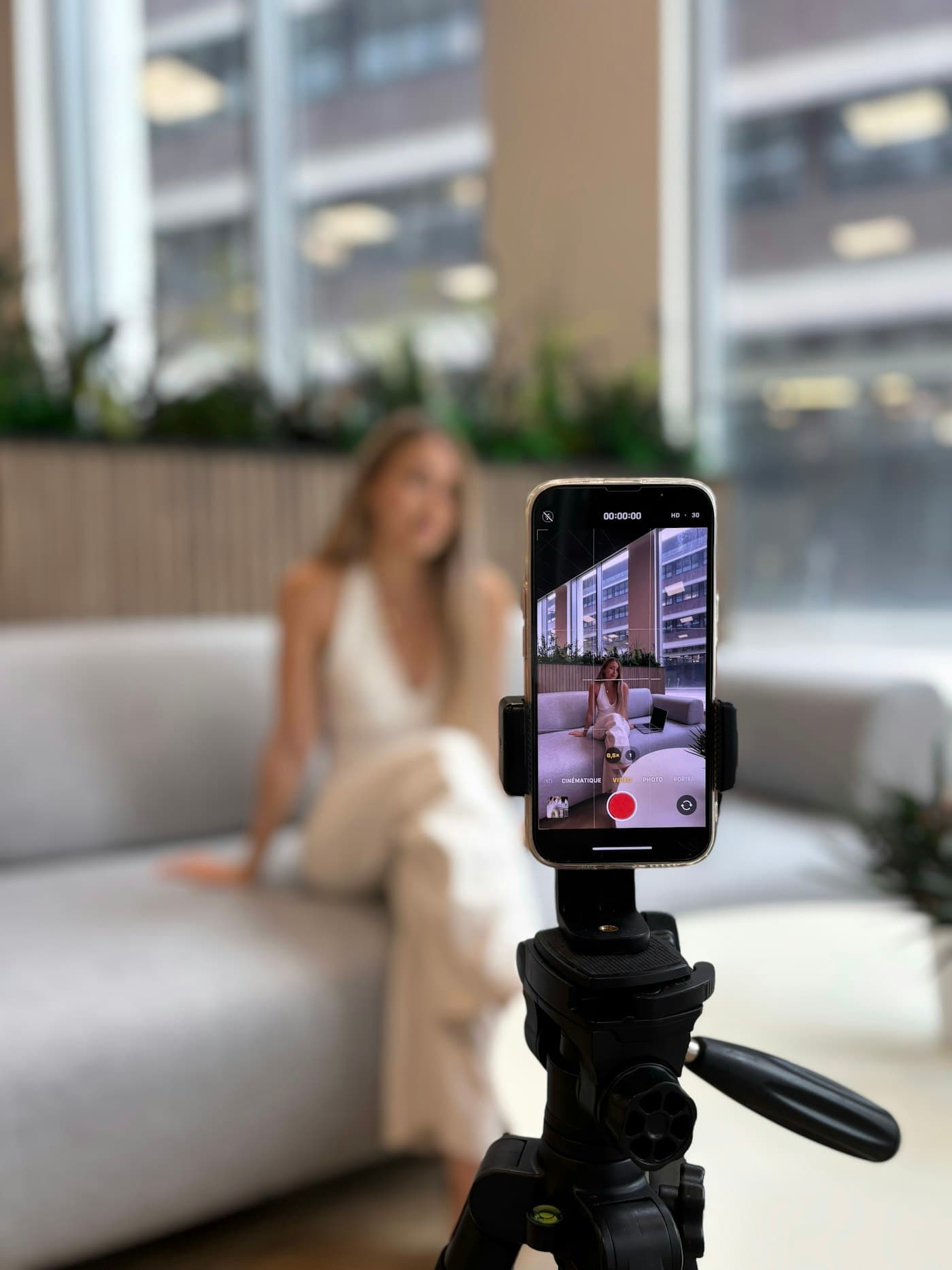 Creatorin nimmt sich mit dem Smartphone auf einem Stativ selbst auf